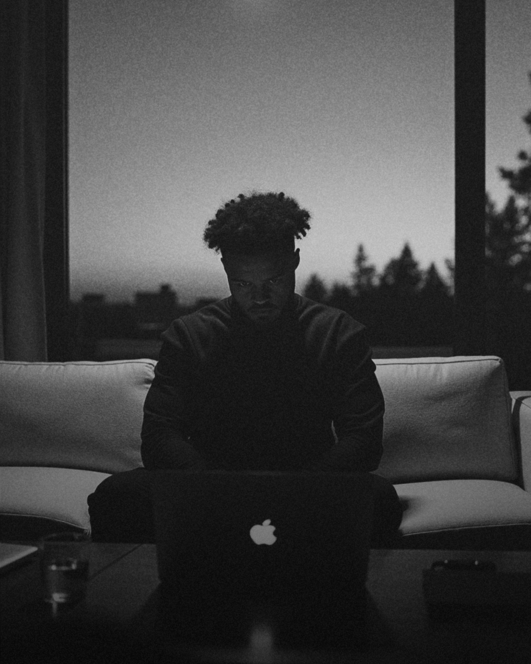 Jared T. Ross at his laptop with a panoramic window behind him
